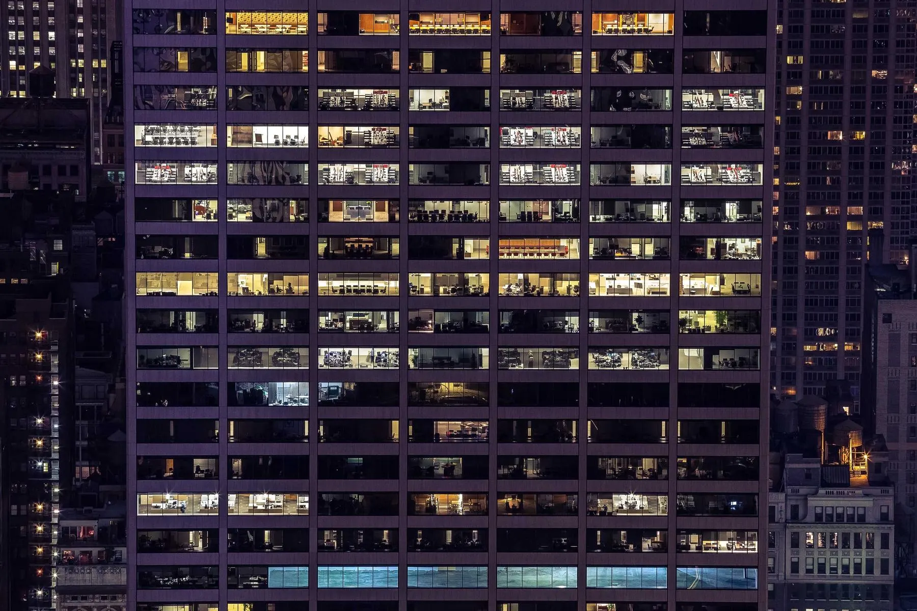 Prédio residencial à noite, com janelas acesas